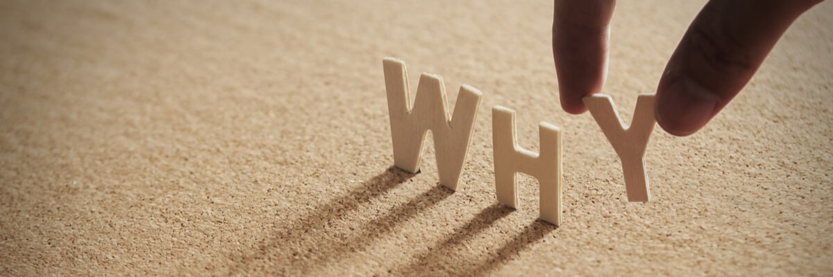 Close up of a hand building out the word why with letters