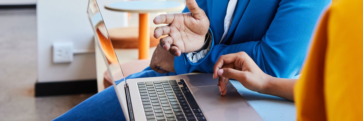 The Real Cost of Delaying Windows 11 Side view of laptop being used by two business colleagues