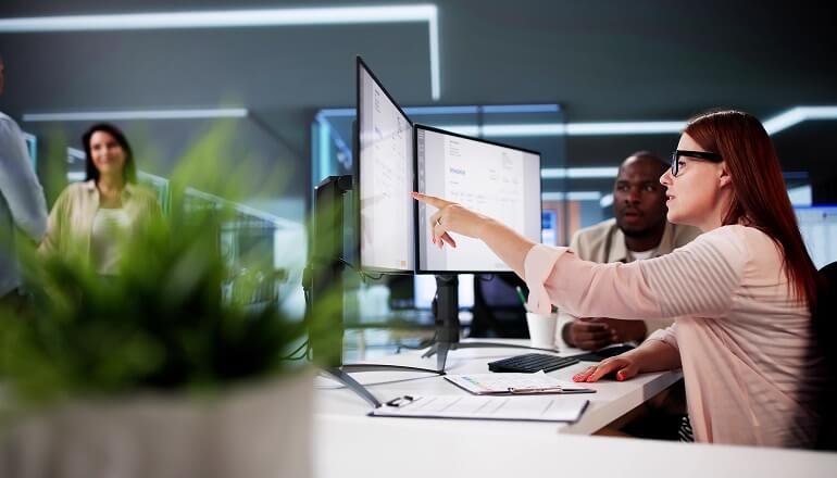 Girl on desktop pointing at monitor