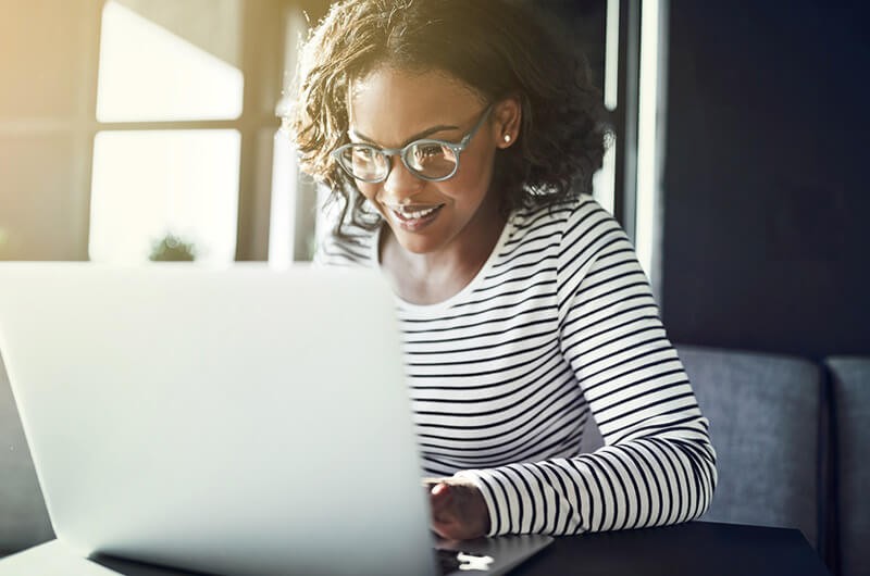 Learn about the technical benefits of Gigamon Smiling remote businesswoman on laptop computer