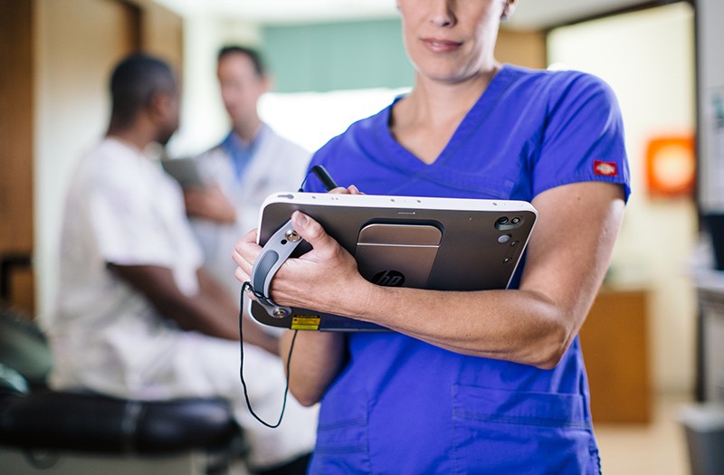 Nurse working on patient stats in hospital roo