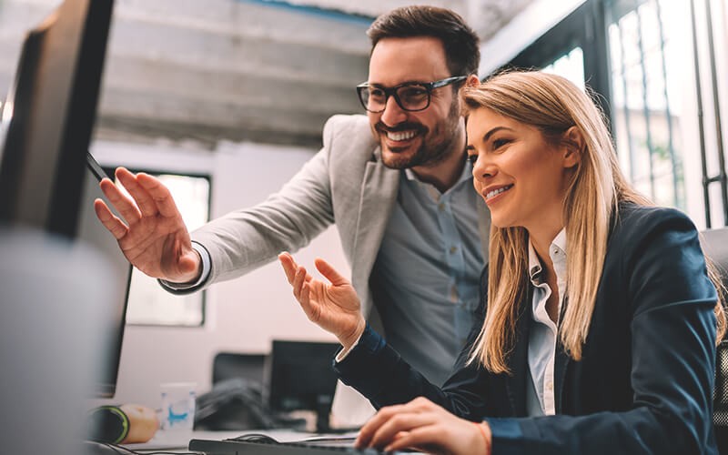 Two professionals working together on workstation computer