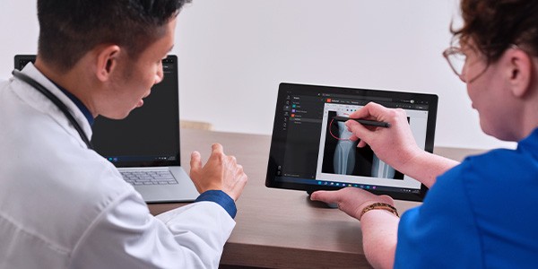 Doctor and nurse review patient data on Microsoft Surface 