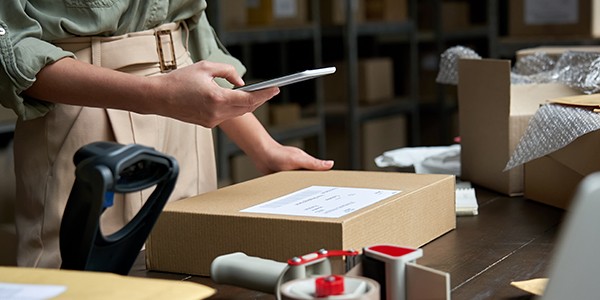 Business owner using mobile device to ease retail workload