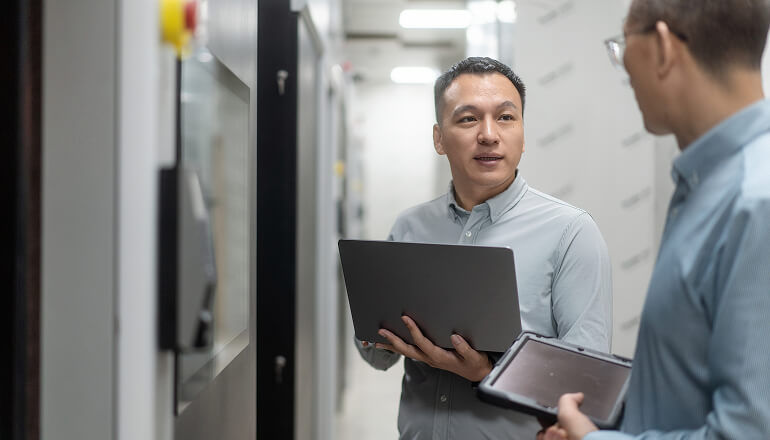 7B+ Data Points Per Day: ORBCOMM’s Data Lake Adapts To Market Guys talking holding tablet and laptop