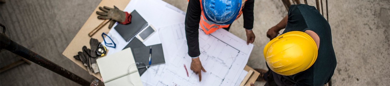 Construction workers review blueprints out on the field and added by technology