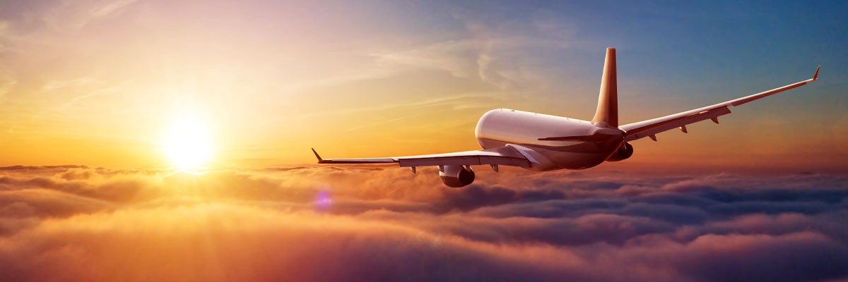 Business Travel Leader Meets Market Challenges With Comprehensive Managed Services Airplane flying above clouds during sunset