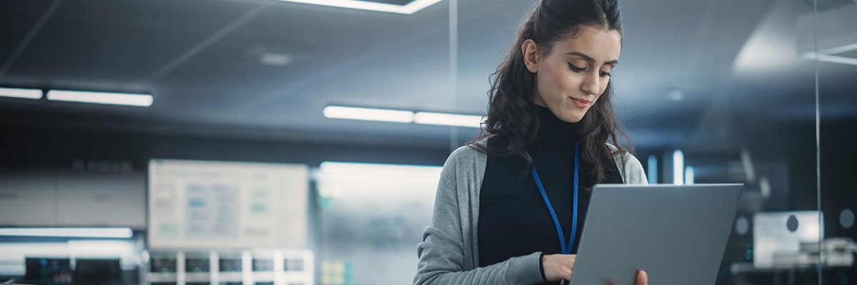 Business professional on laptop in data center