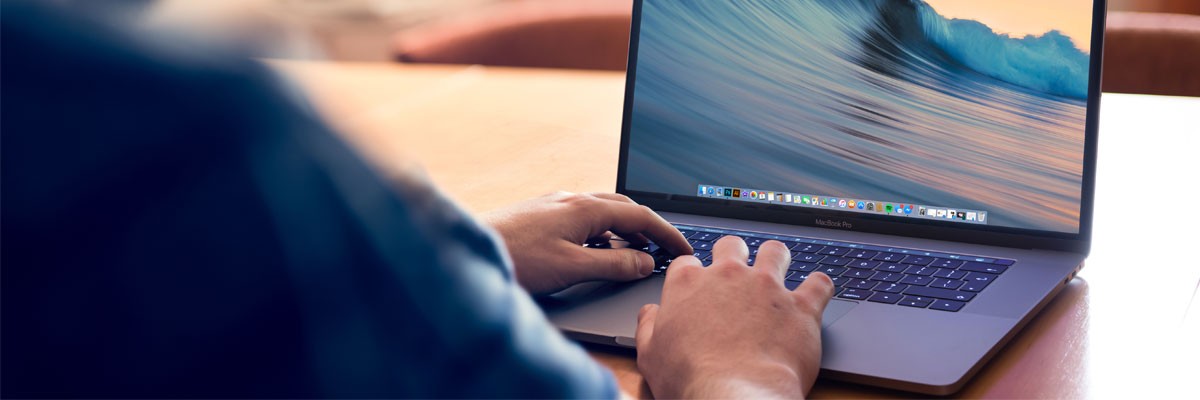 Close up of man using Apple laptop device