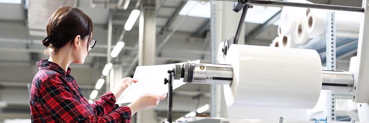 Woman works with printer in global printing company