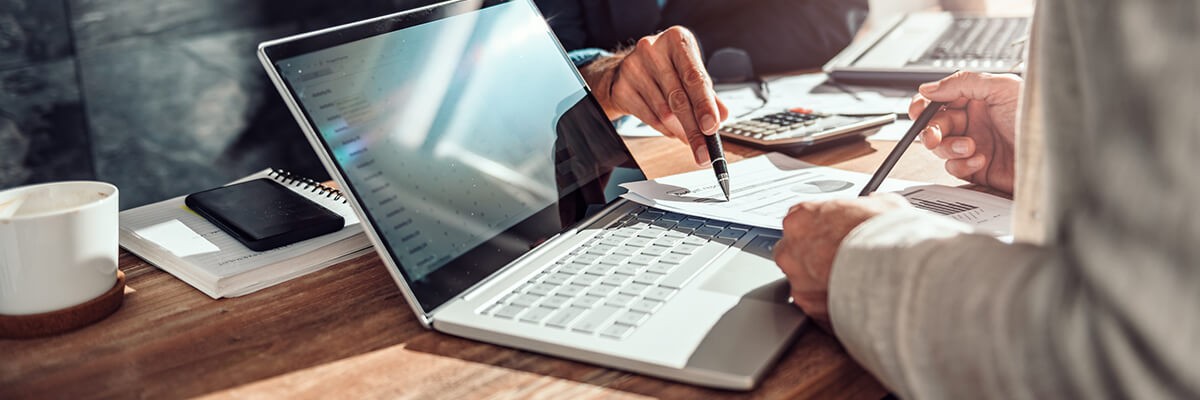 Close up of hands reviewing companies financial results. IT technology licensing.