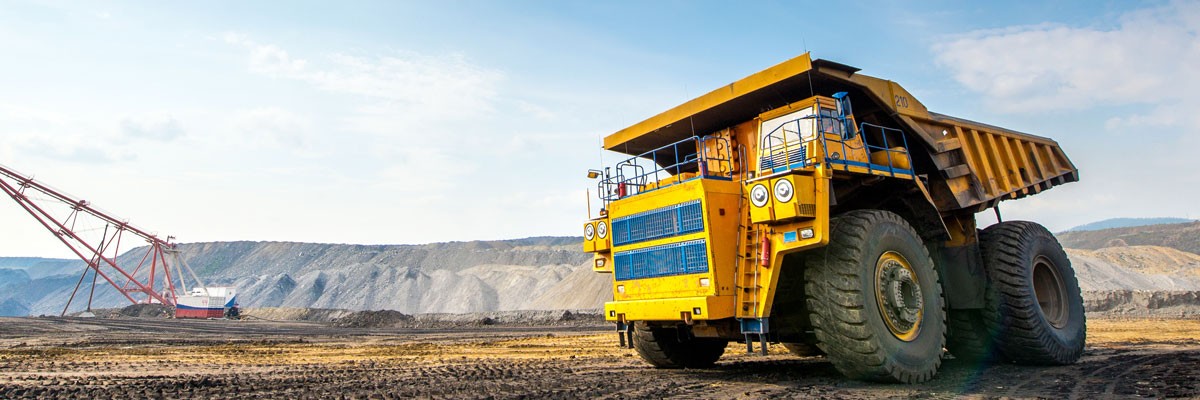 Global Mining Company Taps Into OpEx ROI for Cloud-Native Environment Mining vehicle on dirt planes with mountains in the background