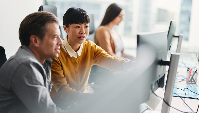 Guidewire propels innovation, collaboration, and productivity by moving to Google Workspace Business people looking at monitor