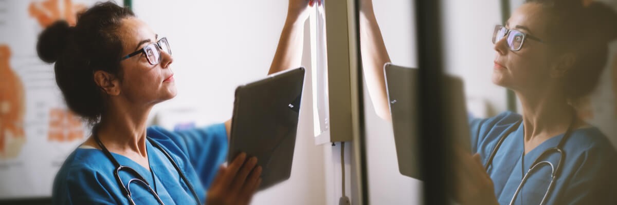 Develop a strategy to be more proactive and prepare for refreshes and software integrations Nurse in hospice changing lighting in patient room.