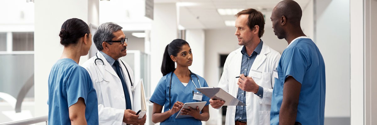 Doctors and nurses discussing patients in hospital hallway