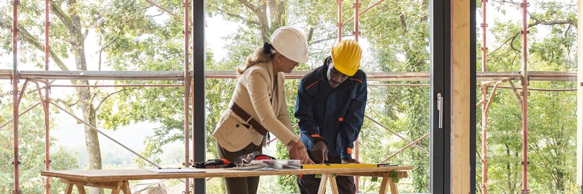 Architect and building planner go over plans for construction of new residential home