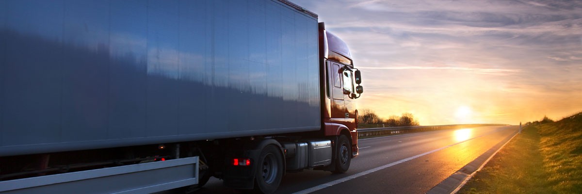 Major Transportation & Logistics Firm Stabilizes Business-Critical Platforms for Increased Uptime Semi-truck driving on highway at sunset