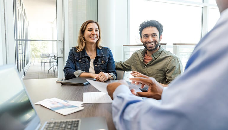 Smiling couple talks with a credit union banker