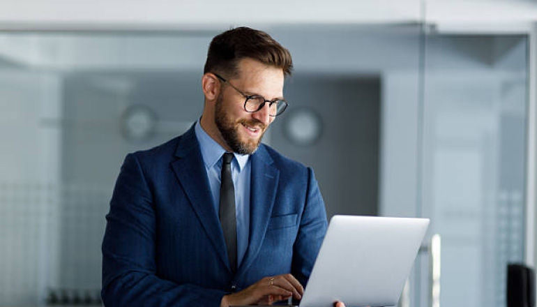 Man working on a laptop wearing a suit