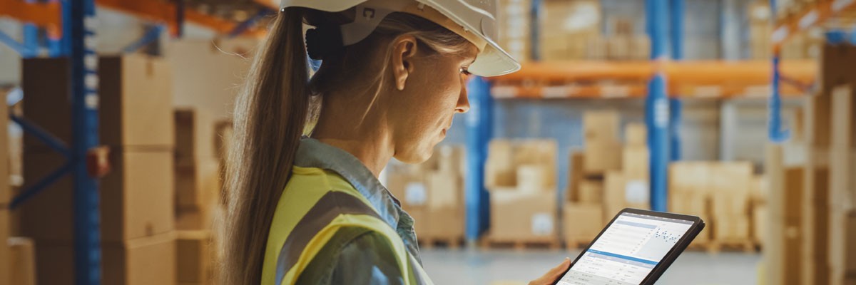 Since engaging Insight, the business has not experienced a single severity one outage Woman in hard hat with tablet in wholesale food manufacturing warehouse