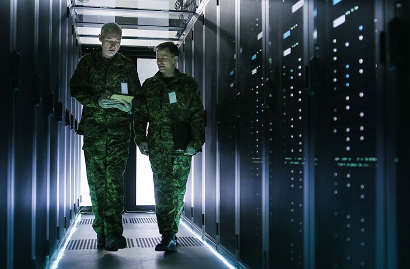 Technology modernization supports military effectiveness. Two department of defense employees walk through data center