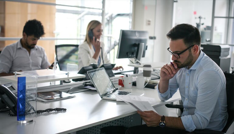 Three team members working in a modern business environment