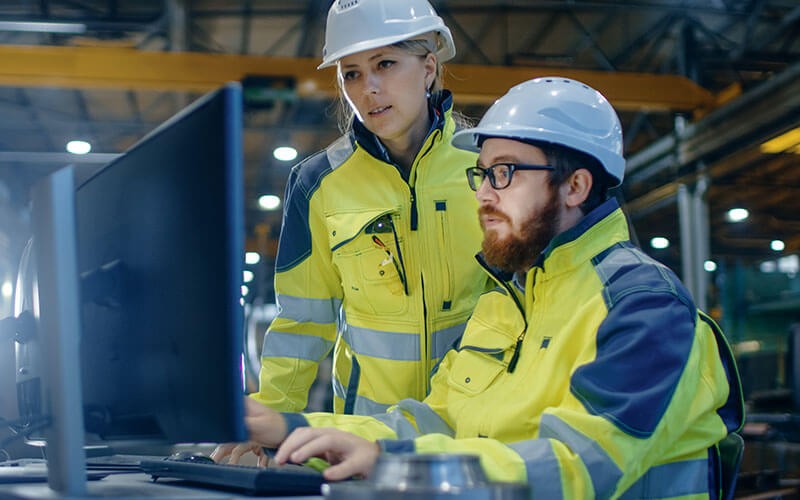Manufacture workers using computer device in warehouse