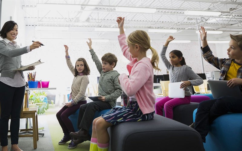 Microsoft classroom technology Children raising their hands in a classroom