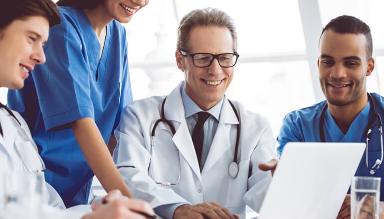 Group of medical professionals gathered around to watch healthcare webinar