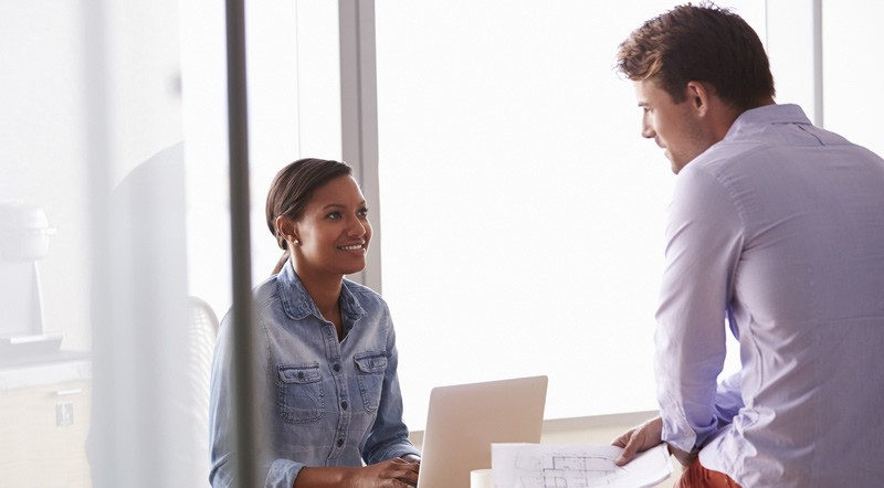 Two young business people discussing their service.