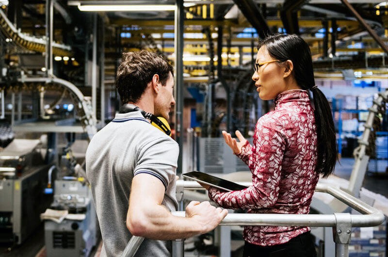 Two employees in factory with technology