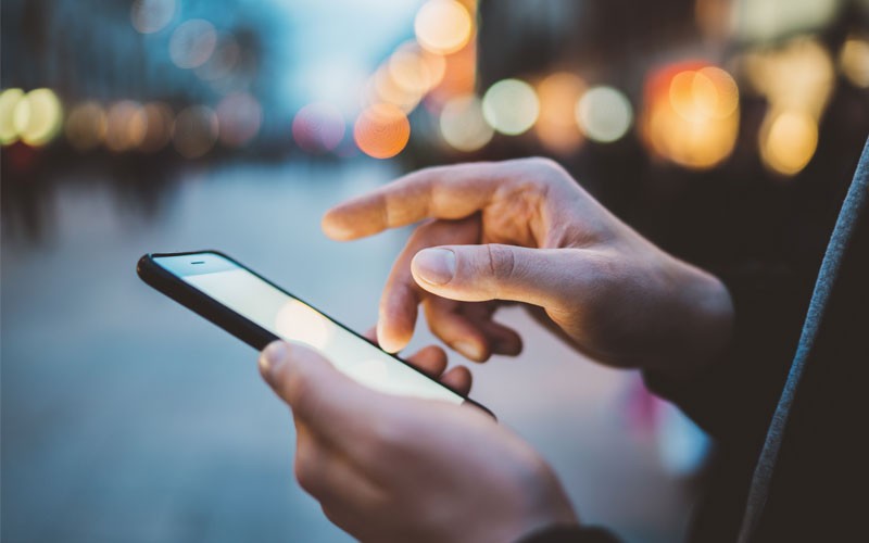Close up of hand touching mobile phone screen