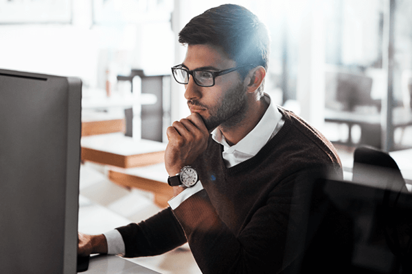 Build a strategy for change without draining resources Serious businessman looking at cost center report on desktop computer