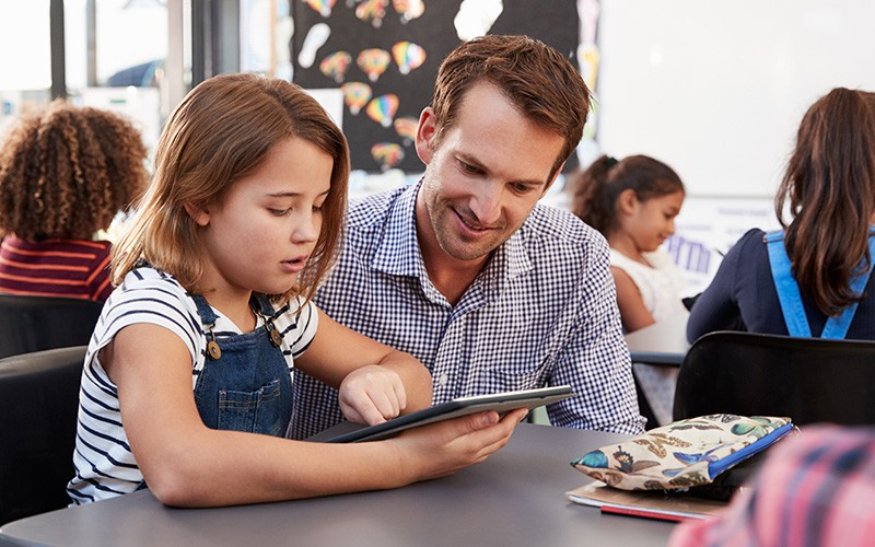 Enhance your edtech ecosystem Teacher helping student with tablet device