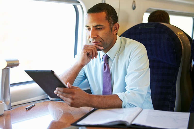Federal employee sitting at table with smart phone and tablet in hand