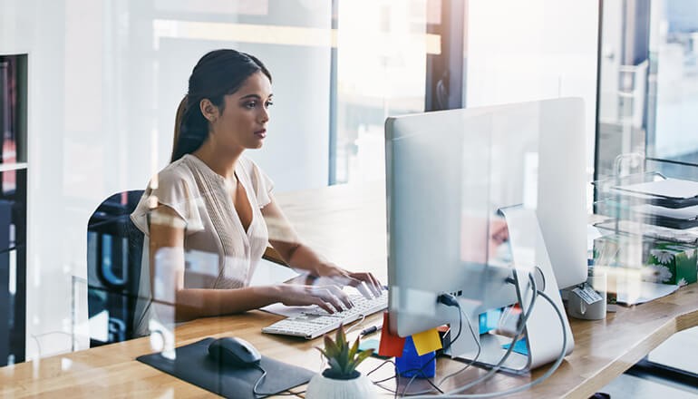 Businesswoman using VMware software on desktop computer