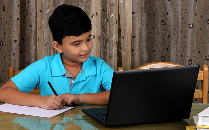 Young student in remote classroom with teacher and fellow students. 