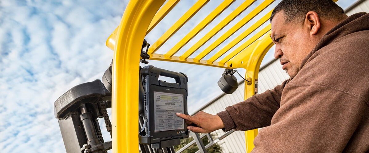 Man pointing to control box while handling construction equipment