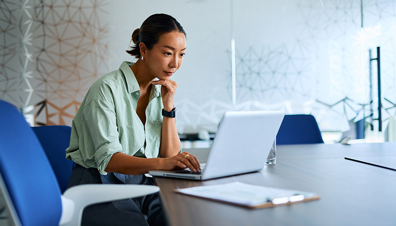 Woman working on laptop in conference room