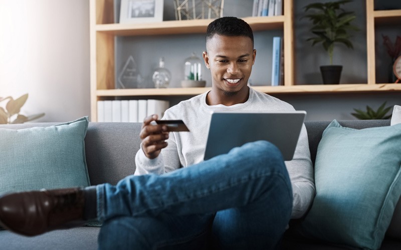 man sitting on couch online shopping