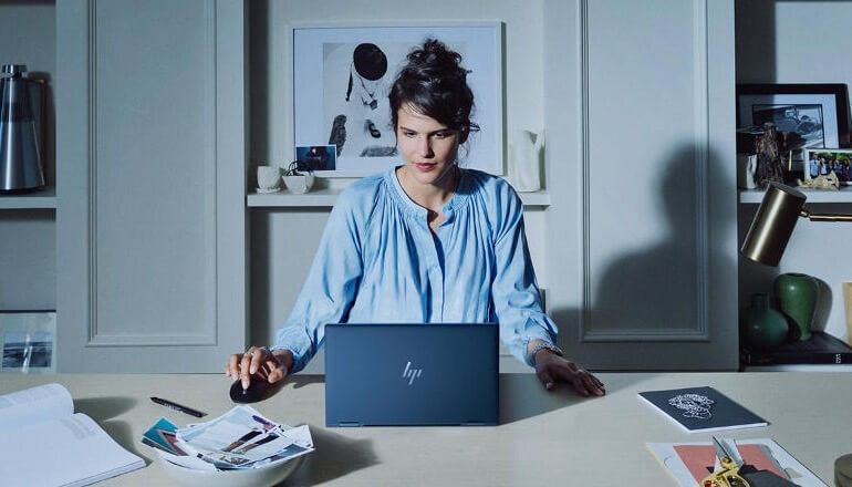 Woman on secure HP computer. HP Wolf Security, cybersecurity, cyberattacks, endpoint security