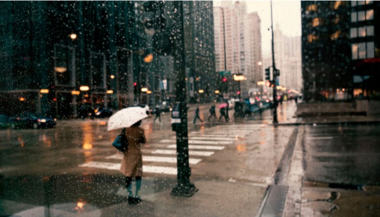 Blurred image of people walking through the rain