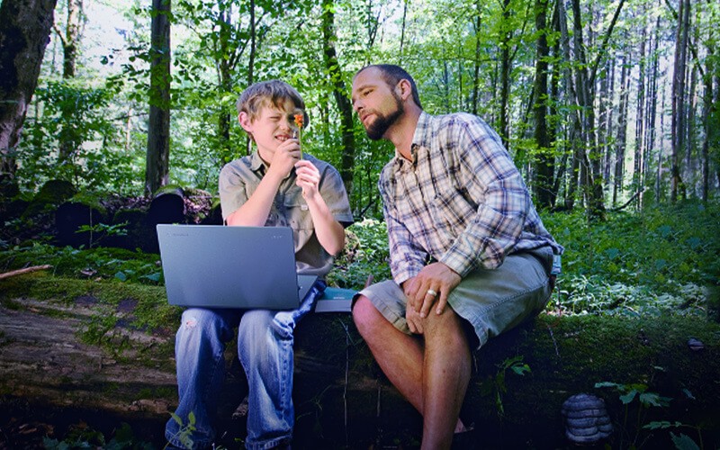 Create a sustainable world Man and a boy with laptop outdoor