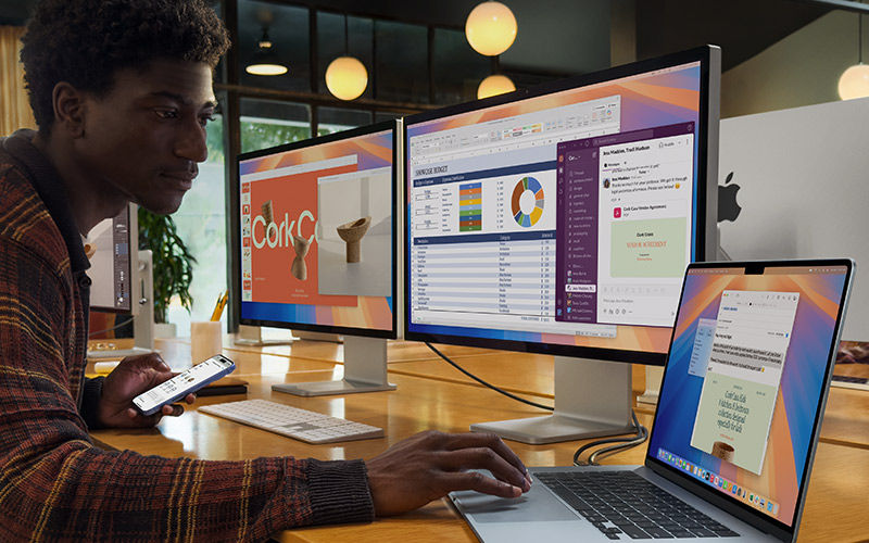 Two people working outside on laptops