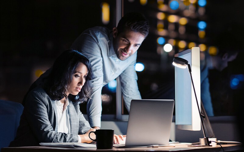 Web application firewall as a service Teammates working together at the office late at night