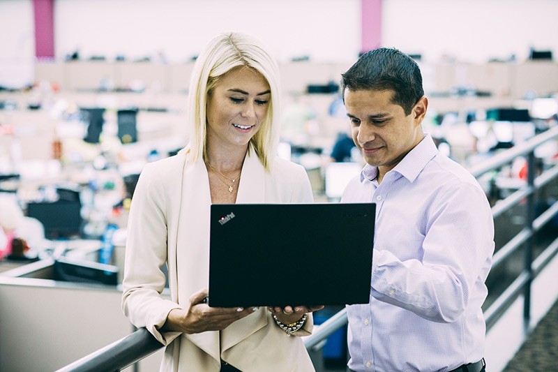 Man and woman in office looking at laptop