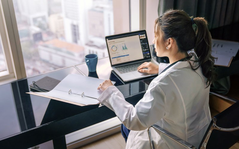 Identify improvements for your processes and workflows Businesswoman reviewing documents in front of cityscape window view