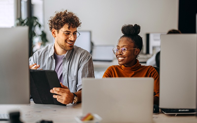 two-colleagues-working-together-on-laptop