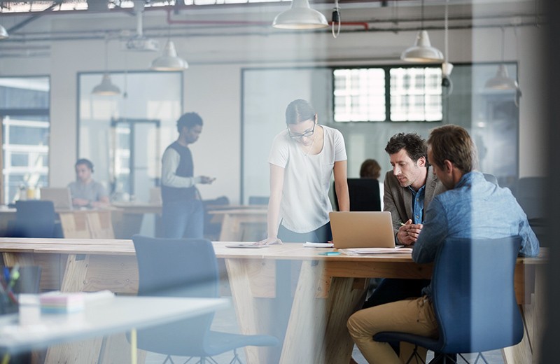 Open office with group of employees collaborating