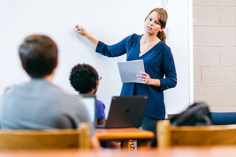 Teacher at whiteboard leading a science class